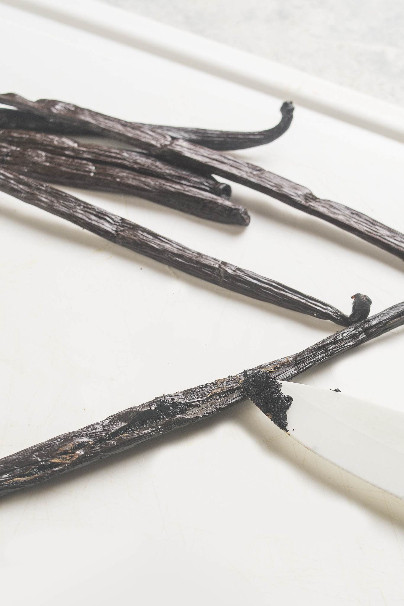 Splitting a vanilla bean and scraping out the seeds with a knife
